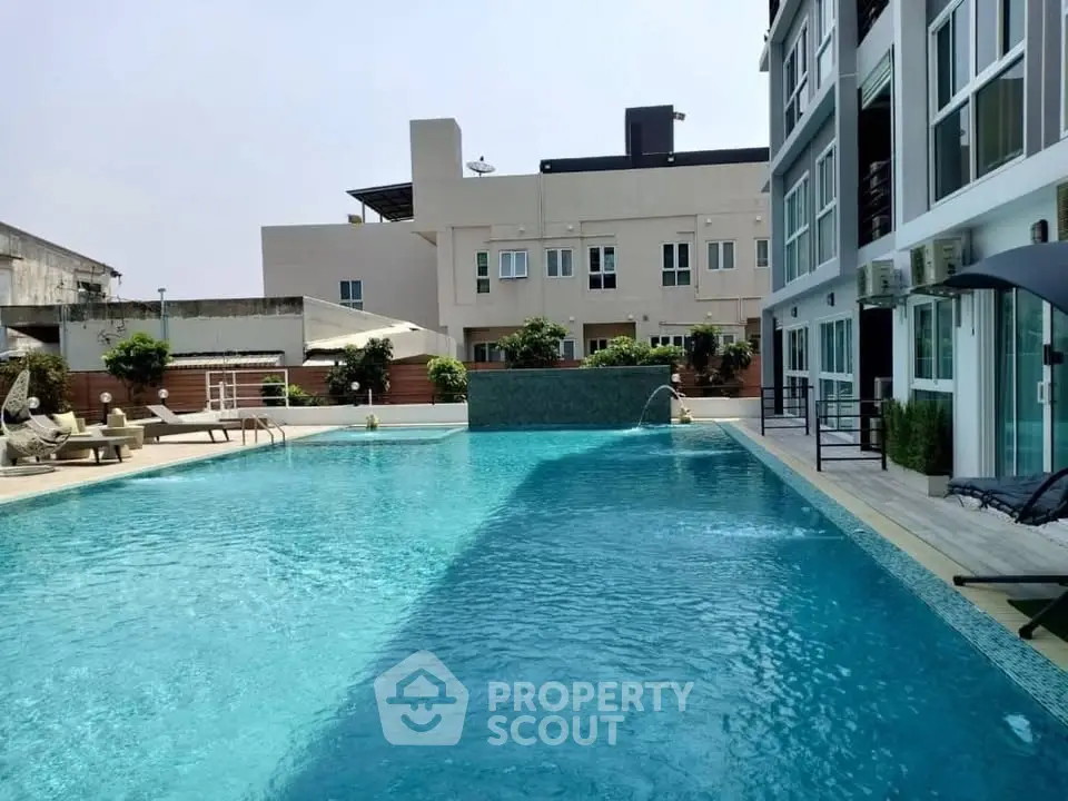 Luxurious apartment complex with a stunning outdoor pool and modern amenities.