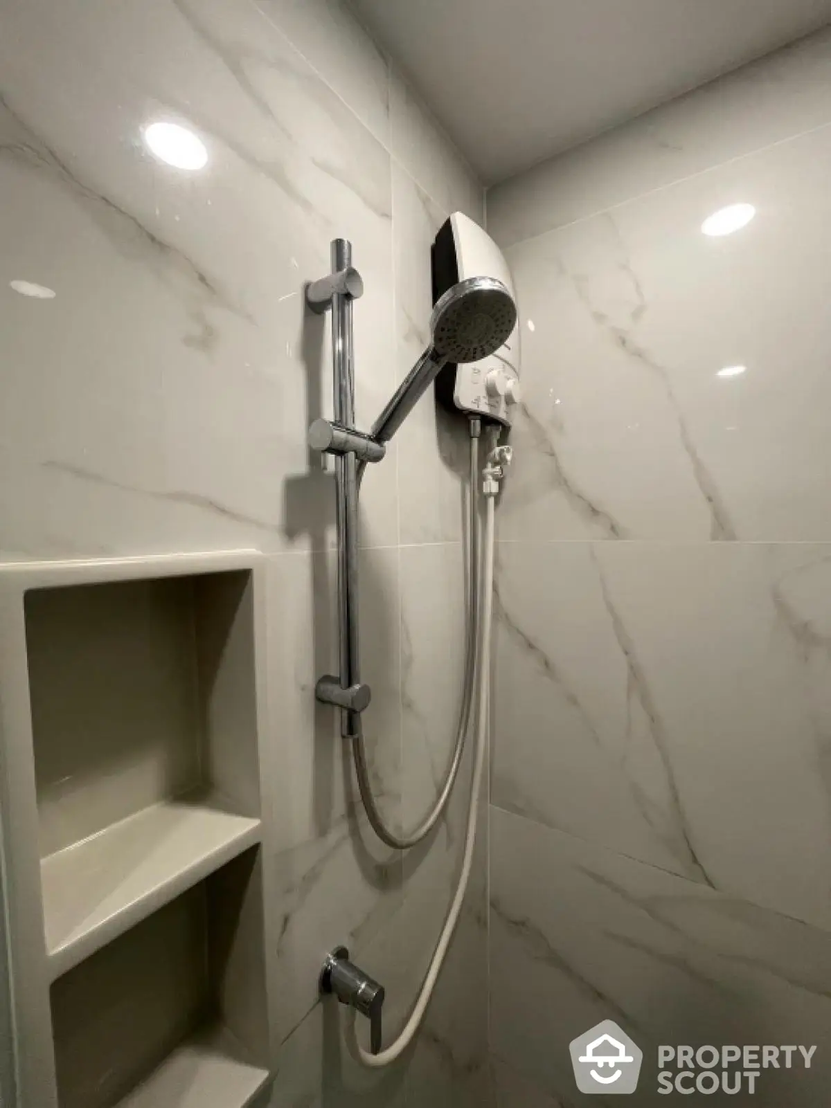 Modern bathroom shower with sleek marble tiles and built-in shelving