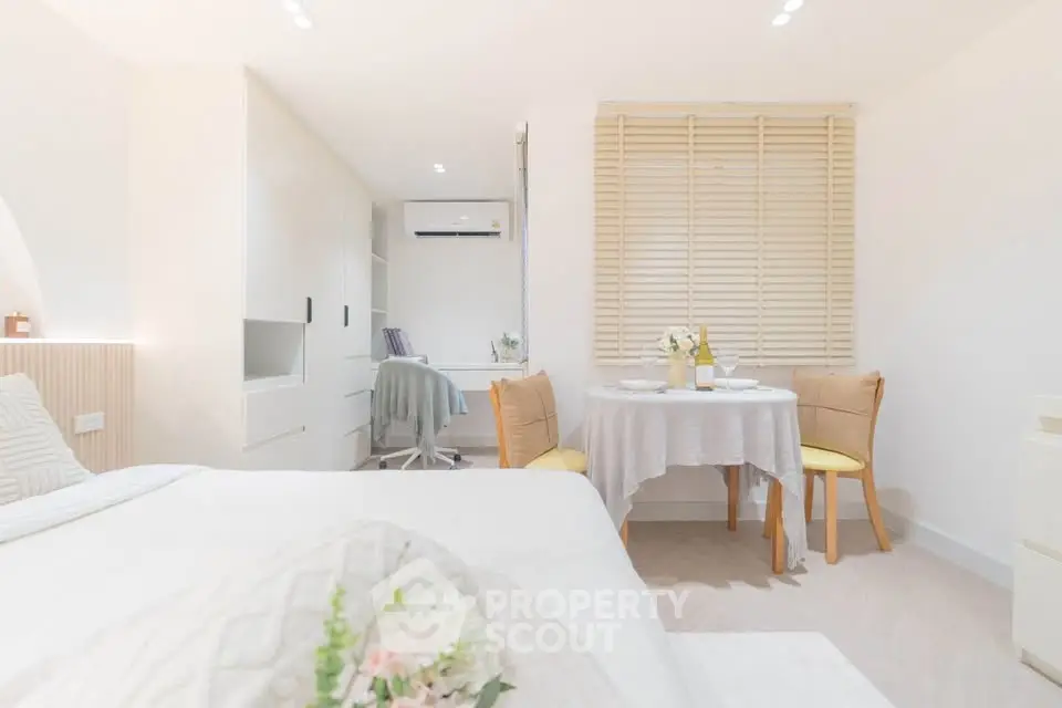 Bright and cozy bedroom with dining area and study nook, featuring modern decor and ample natural light.