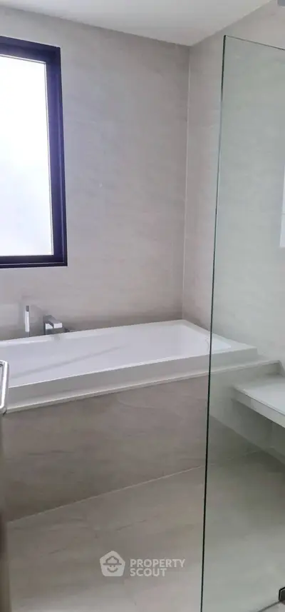 Modern bathroom with sleek bathtub and glass partition