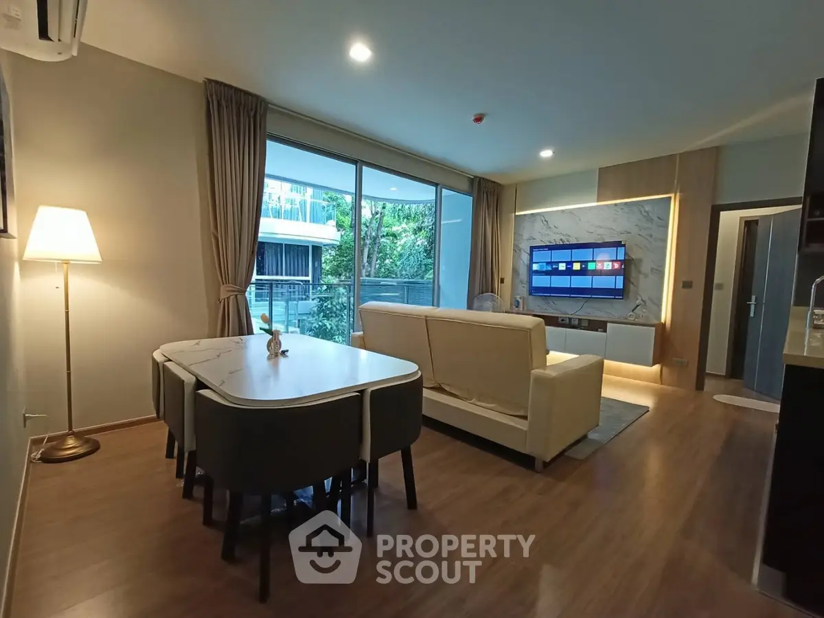 Modern living room with elegant decor and large windows offering a serene garden view