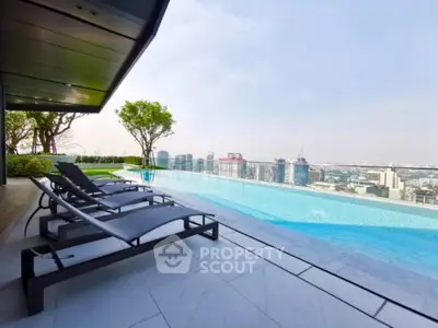 Luxurious rooftop pool with stunning city skyline view and modern lounge chairs.