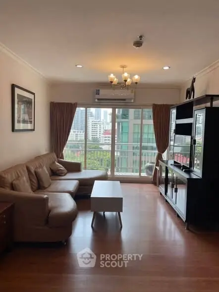 Spacious living room with city view, modern furniture, and natural light in a high-rise apartment.