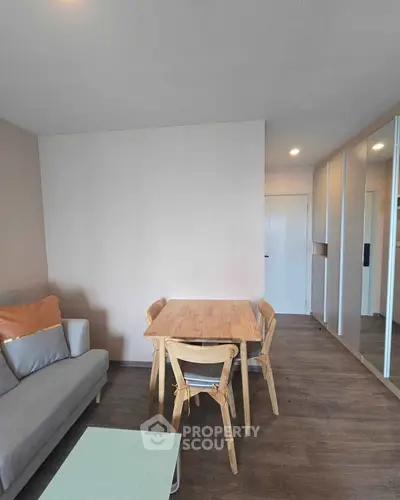 Modern living room with wooden dining set and cozy sofa, perfect for urban living.