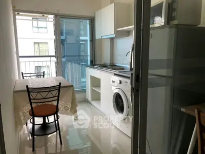 Compact kitchen with washing machine and dining area in modern apartment