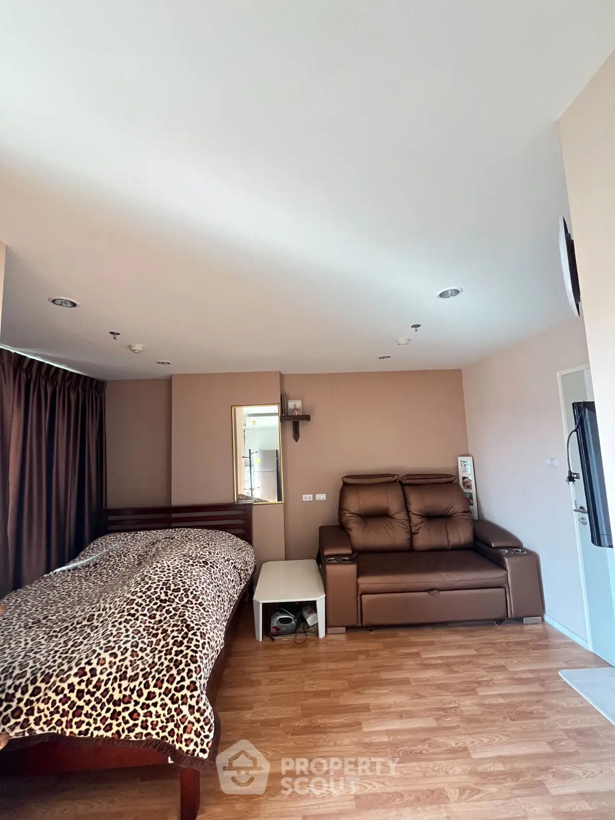 Spacious bedroom with stylish decor and comfortable seating area.
