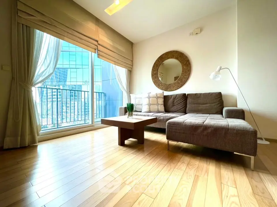 Spacious modern living room with large windows and city view, featuring stylish furniture and wooden flooring.