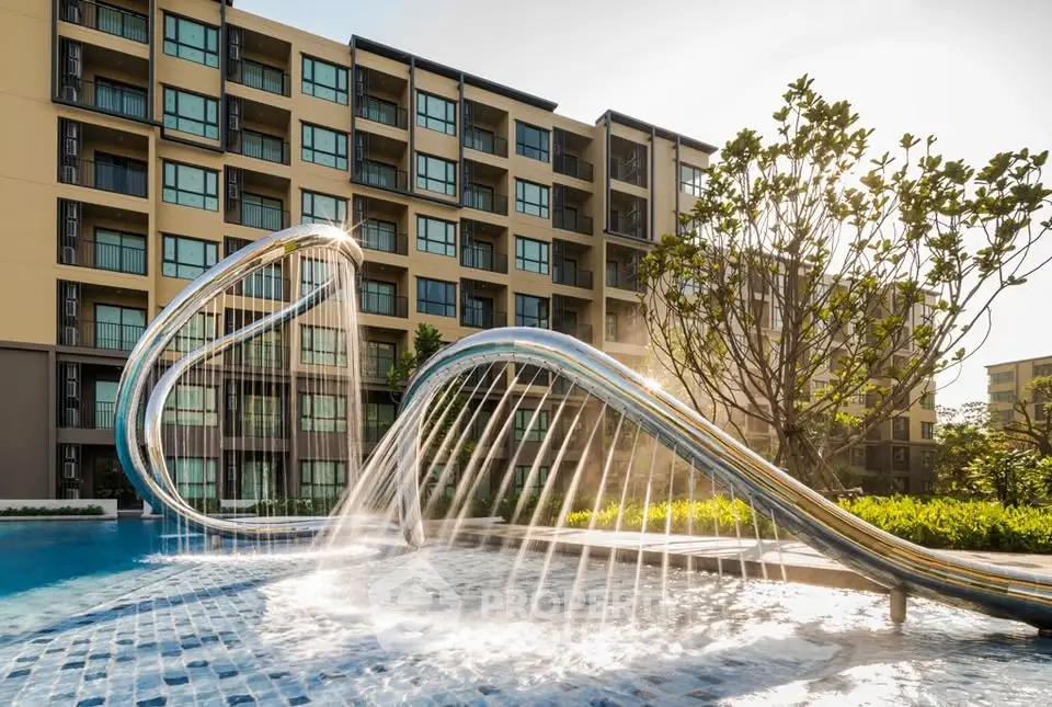 Luxurious apartment complex with modern pool and unique water feature, perfect for upscale living.