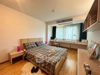 Spacious bedroom with modern decor and natural light, perfect for relaxation.