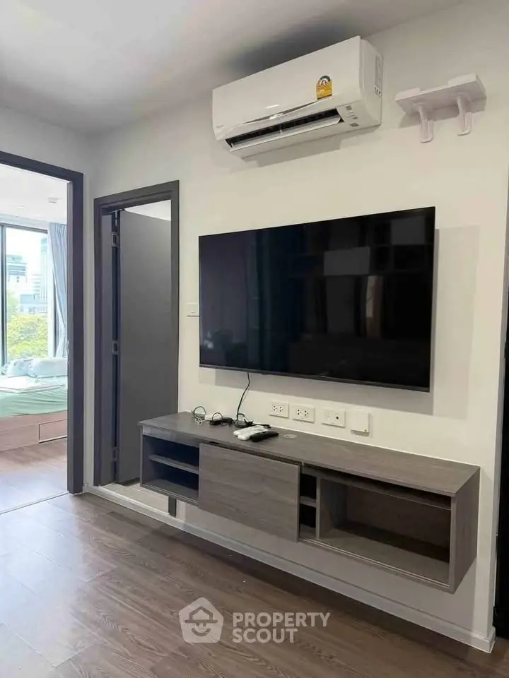 Modern living room with wall-mounted TV and air conditioning in a stylish apartment.