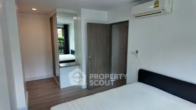 Modern bedroom with sleek design, featuring built-in wardrobe and air conditioning.