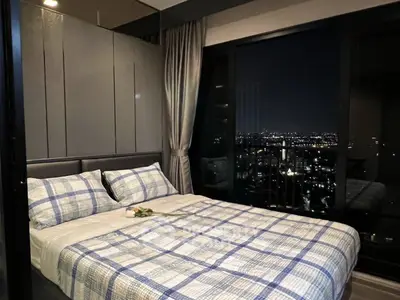 Luxurious bedroom with stunning night city view, featuring modern decor and cozy bedding for ultimate comfort.