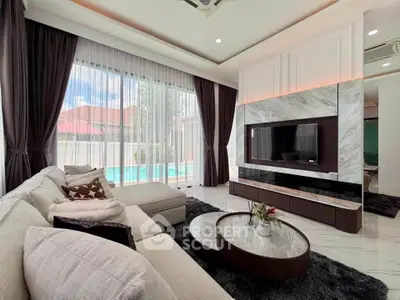Luxurious living room with modern decor, large windows, and pool view, perfect for relaxation and entertainment.