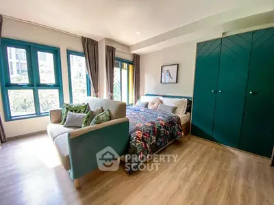 Chic bedroom with vibrant decor and large windows in modern apartment