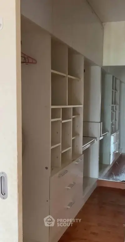 Spacious walk-in closet with ample shelving and mirrored wall in modern home.