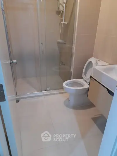 Modern bathroom with glass shower and sleek fixtures in a contemporary home.
