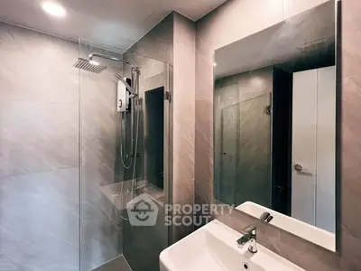 Modern bathroom with sleek shower and stylish sink in contemporary design.