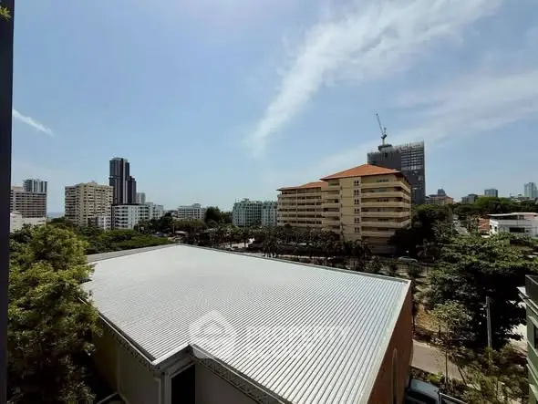 Stunning cityscape view with modern buildings and lush greenery under a clear blue sky.