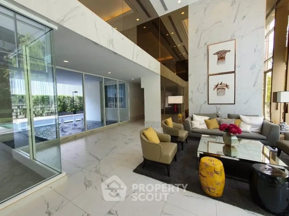 Luxurious modern lobby with elegant seating and marble flooring, featuring a pool view through glass walls.