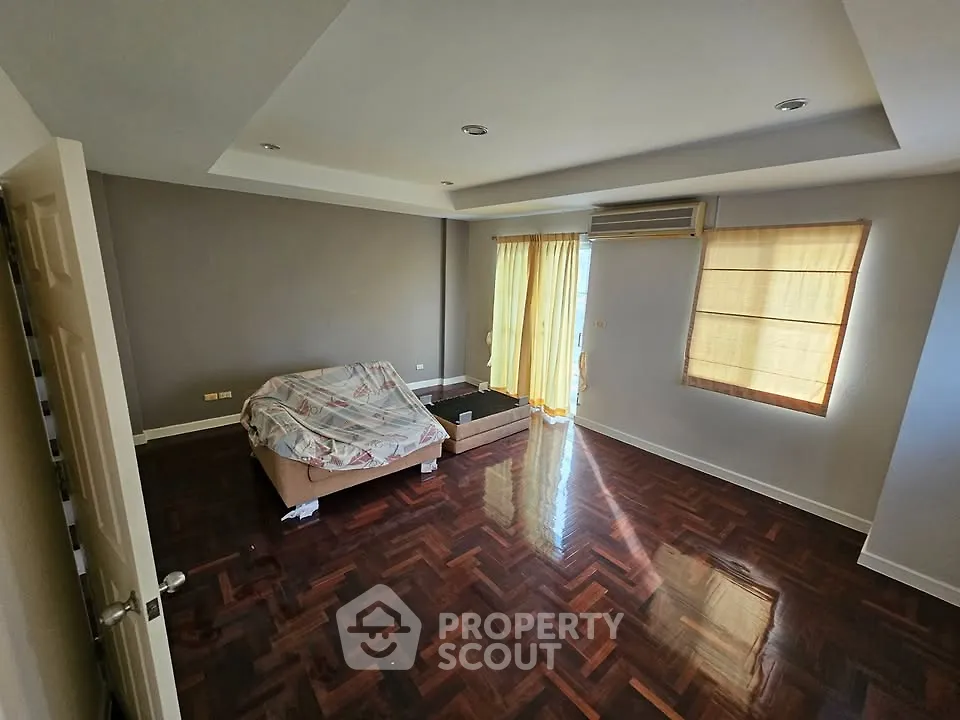 Spacious living room with hardwood floors and natural light