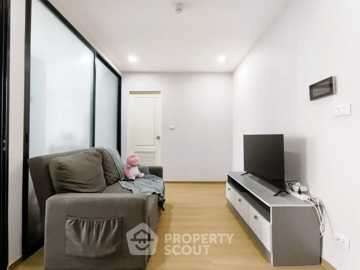 Modern living room with sleek TV stand and cozy sofa in minimalist apartment.