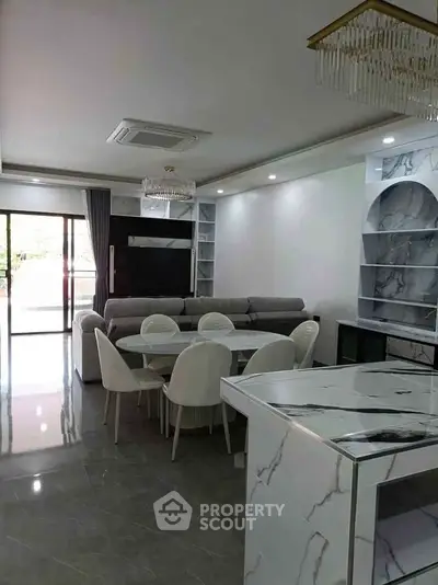 Modern living room with elegant marble accents and spacious dining area