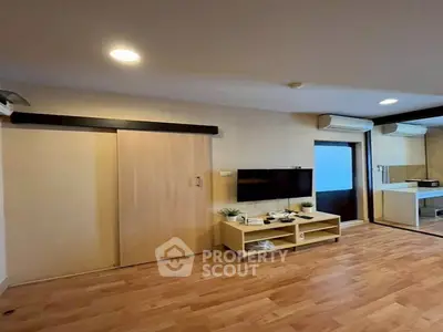 Modern living room with wooden flooring and sleek TV setup