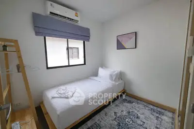 Cozy minimalist bedroom with single bed, air conditioning, and modern decor.