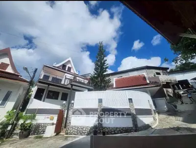 Charming hillside homes with unique architecture and lush surroundings under a vibrant blue sky.