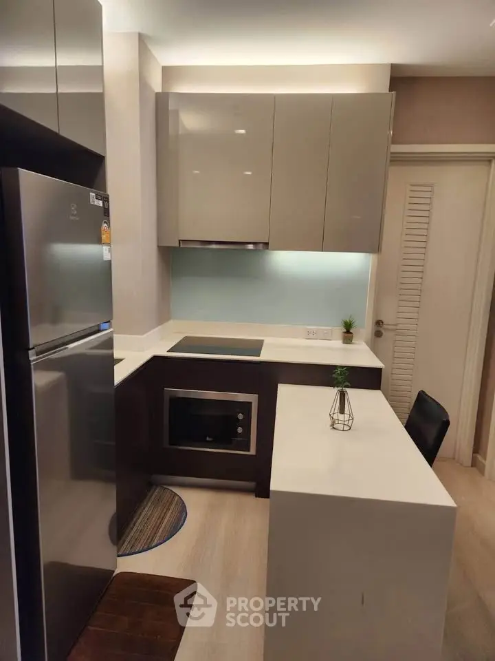 Modern kitchen with sleek cabinetry and built-in appliances in a compact layout.