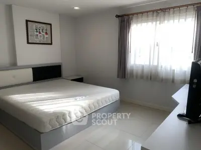 Spacious bedroom with natural light and modern furnishings