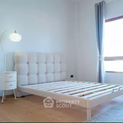 Bright and airy bedroom with modern bed frame and stylish lamp