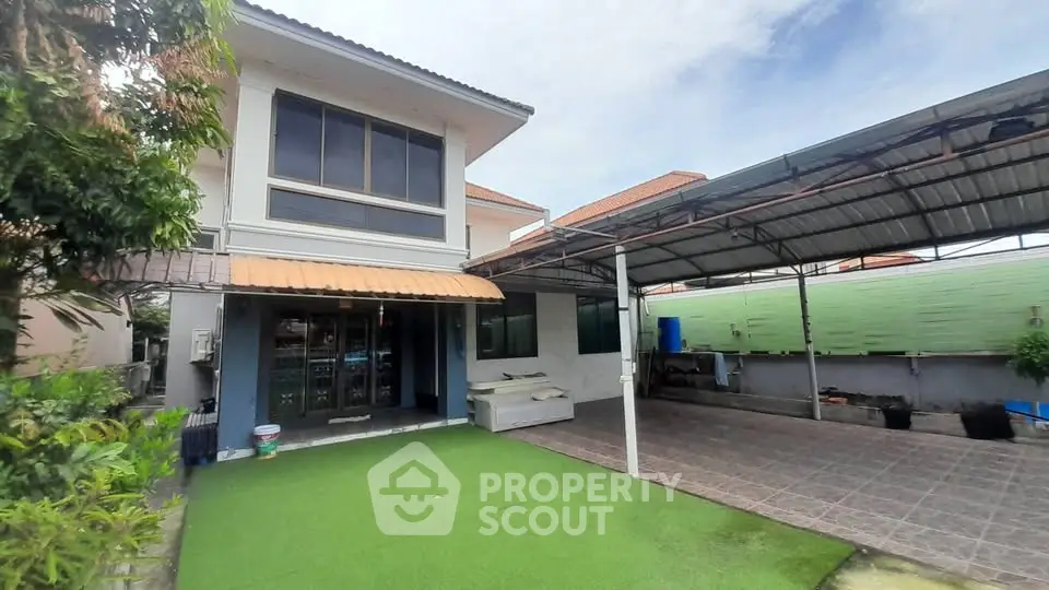 Charming two-story house with spacious carport and lush garden area, perfect for family living.
