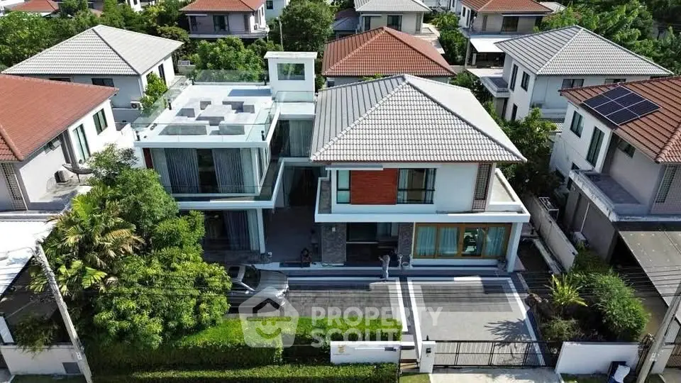 Luxurious modern house with spacious driveway and lush greenery in a serene neighborhood.