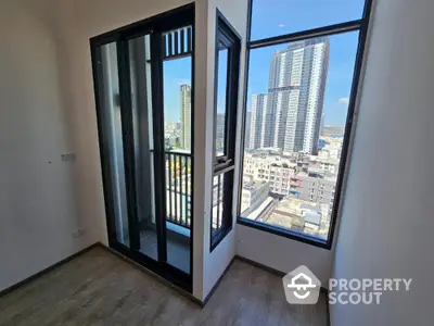 Bright and airy corner unit with expansive windows offering a panoramic city view, modern flooring, and access to a spacious balcony.