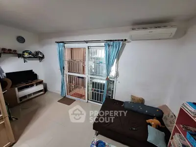 Cozy living room with air conditioning and natural light, featuring a compact entertainment setup.