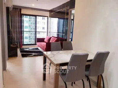 Modern living room with stylish dining area and city view, featuring a chic red sofa and elegant marble table.