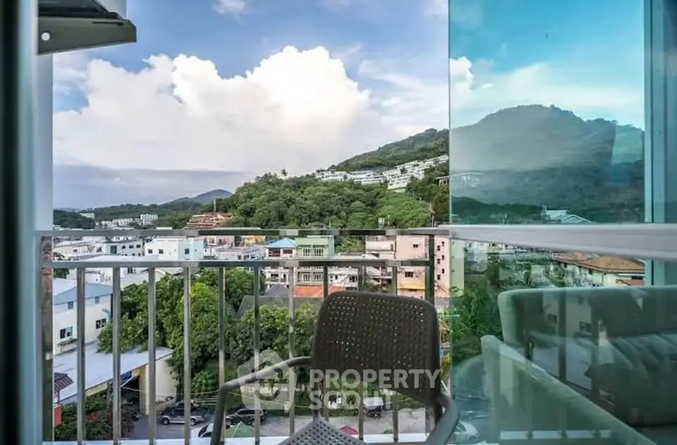 Stunning balcony view with lush green hills and cityscape, perfect for relaxation.