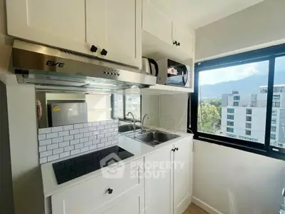 Modern kitchen with sleek cabinetry and scenic window view in urban apartment