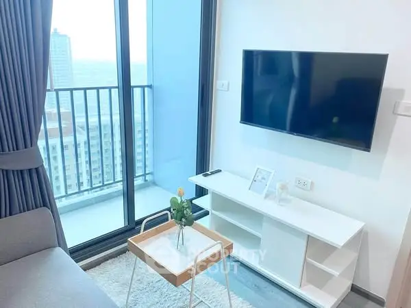 Modern living room with balcony view and wall-mounted TV in a stylish apartment.