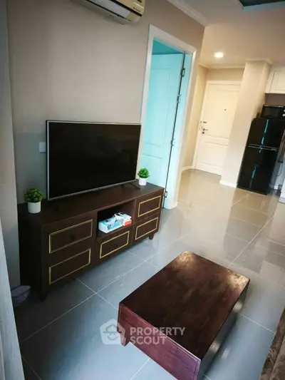 Modern living room with sleek TV stand and compact furniture in a stylish apartment.