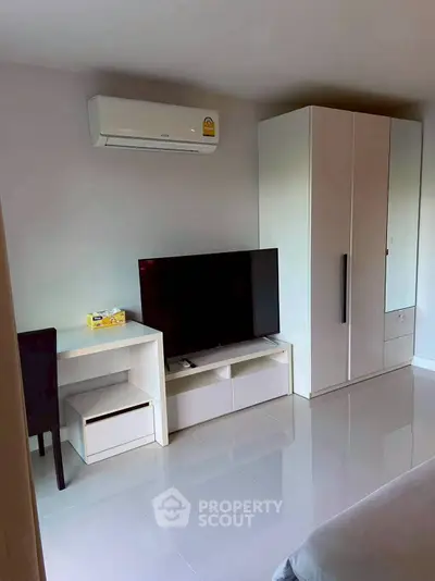 Modern bedroom with sleek furniture, air conditioning, and a flat-screen TV for ultimate comfort.