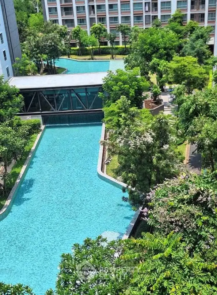 Luxurious residential complex with stunning pool and lush greenery, offering a serene and upscale living environment.