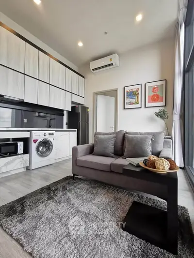 Modern living room with stylish kitchen and cozy sofa in open layout apartment.
