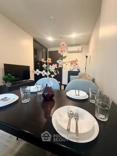Modern dining area with elegant table setting and cozy living room ambiance.