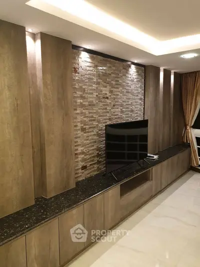 Luxurious living room with modern TV unit and elegant stone accent wall