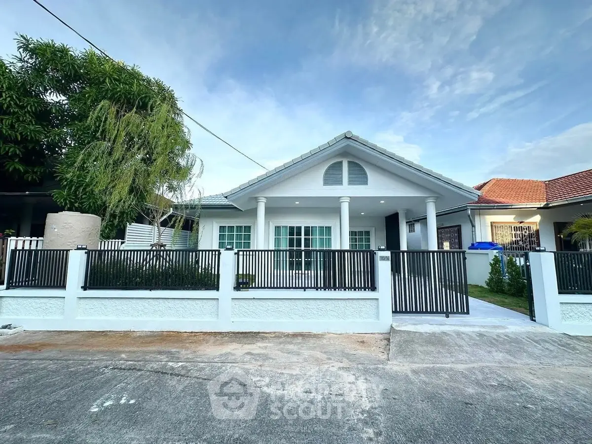 Charming single-story house with modern facade and spacious front yard in a serene neighborhood.