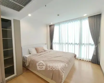 Spacious bedroom with large window and modern decor