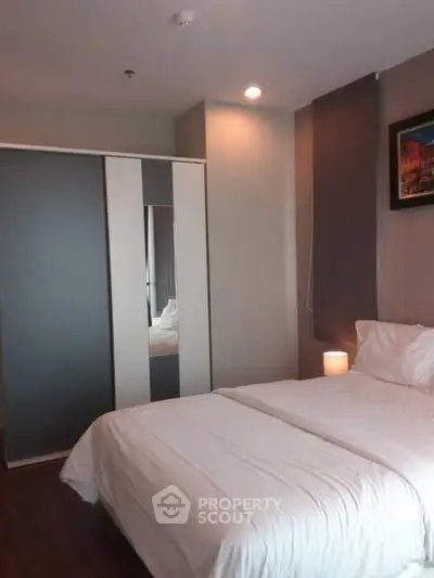 Cozy bedroom with modern wardrobe and soft lighting, perfect for relaxation.