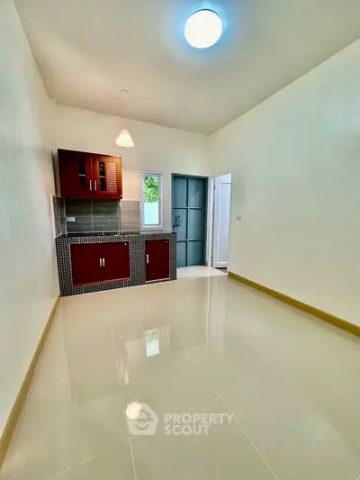 Modern minimalist kitchen with sleek cabinetry and glossy tiled floor.